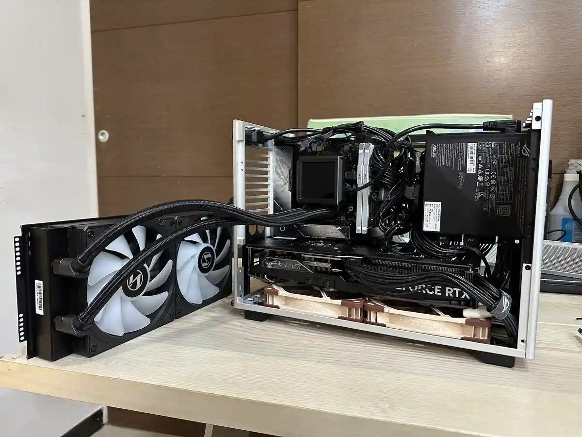 A custom-built PC with its side panel removed, revealing a densely packed interior with a large liquid cooling radiator…