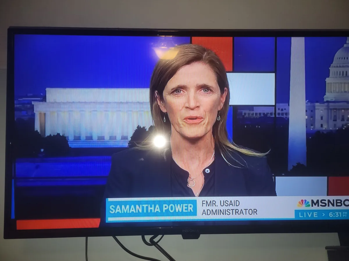 A television screen shows a news broadcast from MSNBC featuring Samantha Power, identified as 'FMR. USAID ADMINISTRATOR'…