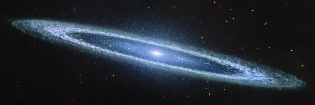A wide-angle photograph of a spiral galaxy, likely the Andromeda Galaxy, showing its bright central core and swirling…