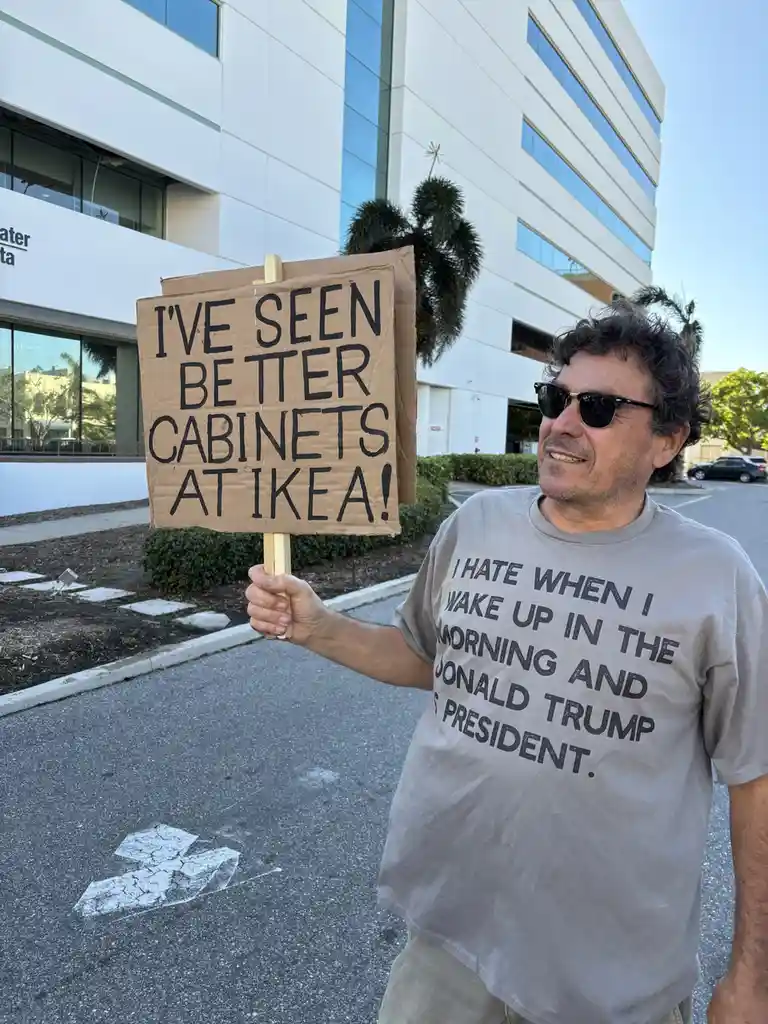 A man wearing sunglasses and a t-shirt that reads 'I HATE WHEN I WAKE UP IN THE MORNING AND DONALD TRUMP IS PRESIDENT.'…
