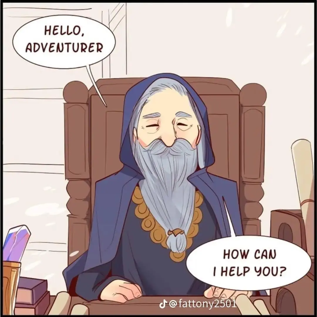 An elderly, bearded man in a blue hooded robe sits in a wooden chair behind a desk, smiling warmly. He has a long grey beard…