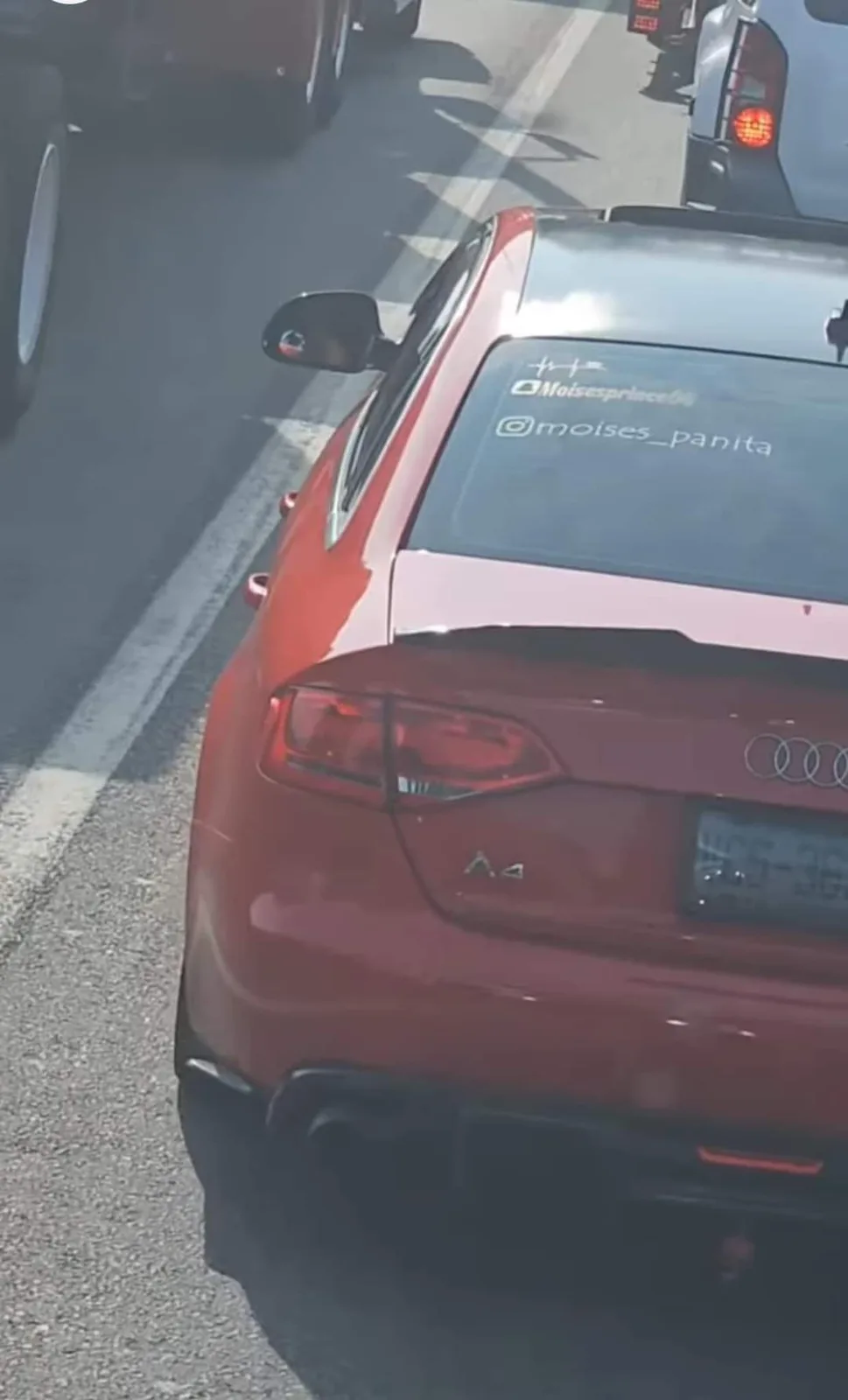A red Audi A4 sedan is shown from behind in traffic, with two Instagram handles, @moisesprince04 and @moises_panita, visibly…