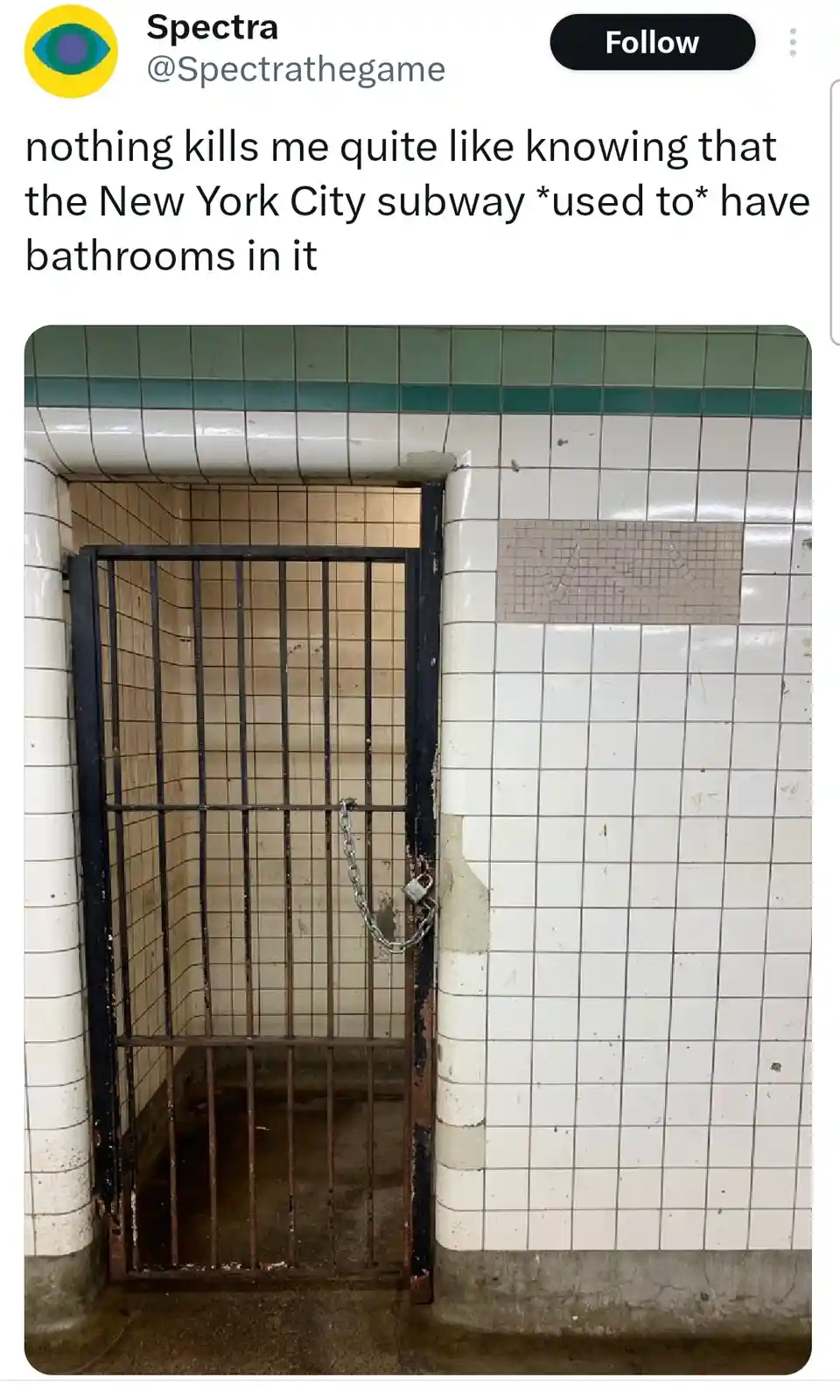 A photo shows a dilapidated, rusted metal gate with a chain and padlock, blocking a tiled subway alcove. The walls are…