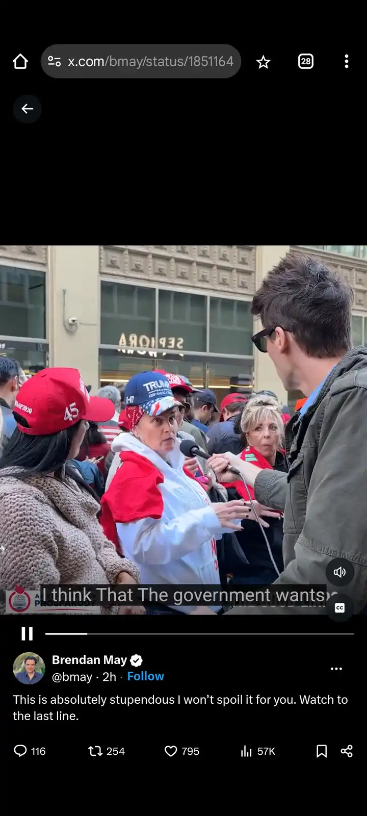 A woman wearing a blue 'TRUMP 45' cap and red-and-white jacket is being interviewed by a man holding a microphone outdoors…