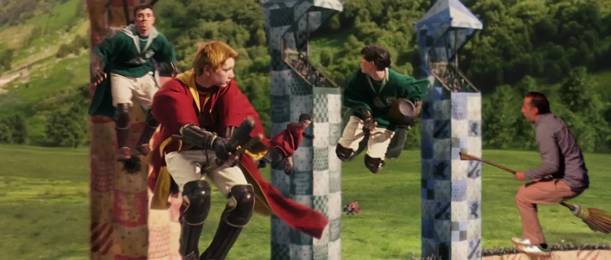 A still from the Harry Potter movies shows several young men on broomsticks playing quidditch, with one player in a red robe…