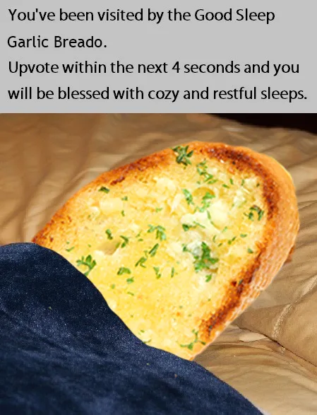 A close-up photo shows a single slice of garlic bread resting on a bed with a dark blue blanket partially covering it. The…