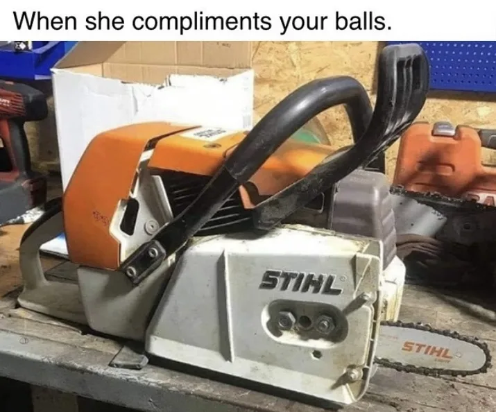 A close-up photo of a STIHL brand chainsaw resting on a wooden workbench, with its black handles and orange engine housing…