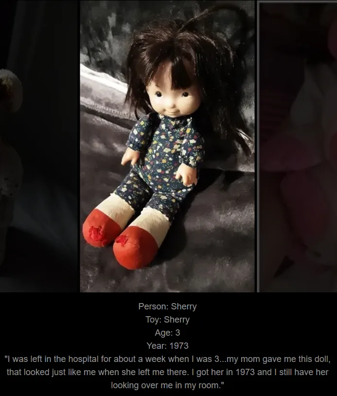 A vintage doll with dark hair, a floral-patterned one-piece outfit, and red-and-beige socks sits on a dark fabric surface…