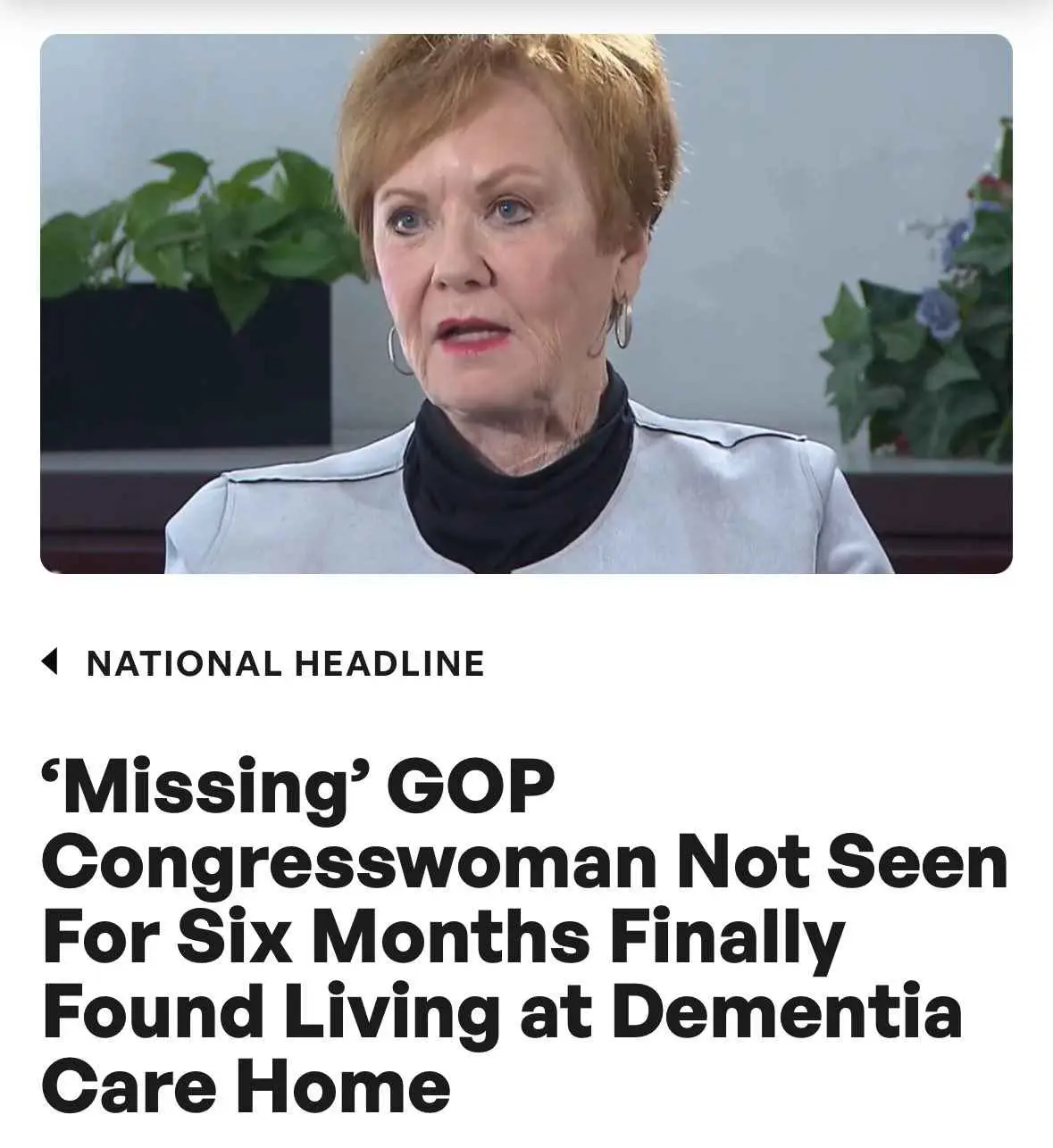 A woman with short red hair and hoop earrings, wearing a light gray jacket over a black turtleneck, appears in a news-style…