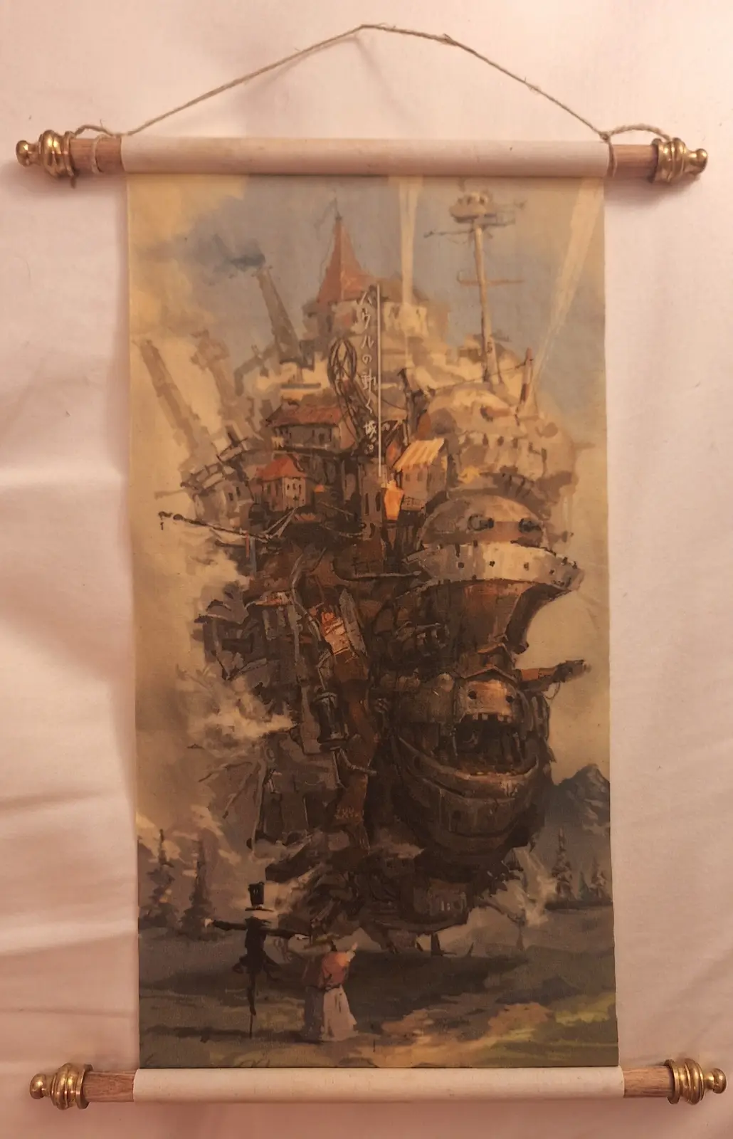 A scroll-style wall hanging displays a watercolor painting of the massive, steampunk-inspired flying castle from Studio…