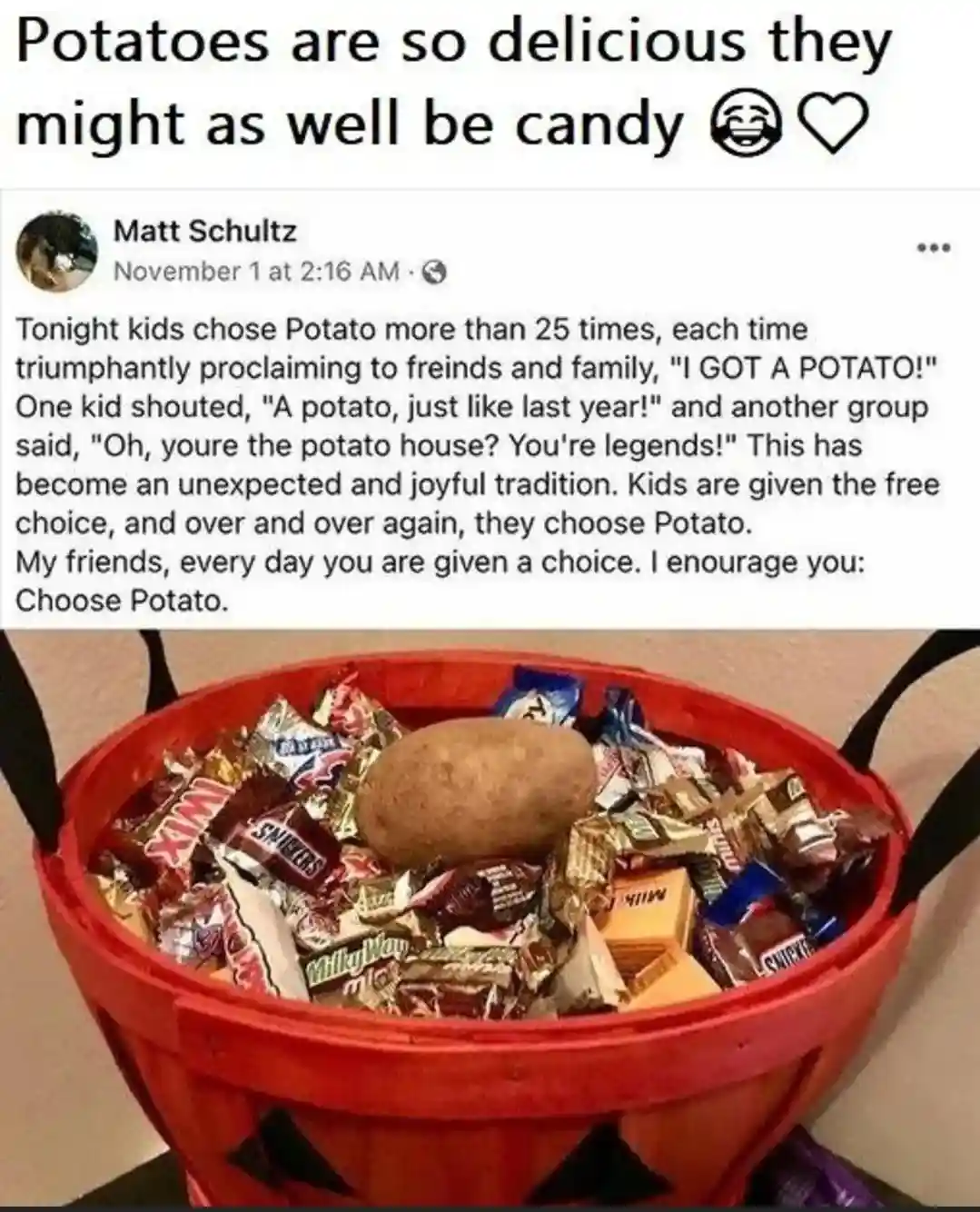 A red Halloween candy bucket filled with various wrapped candies, with a single potato prominently placed on top. The image…