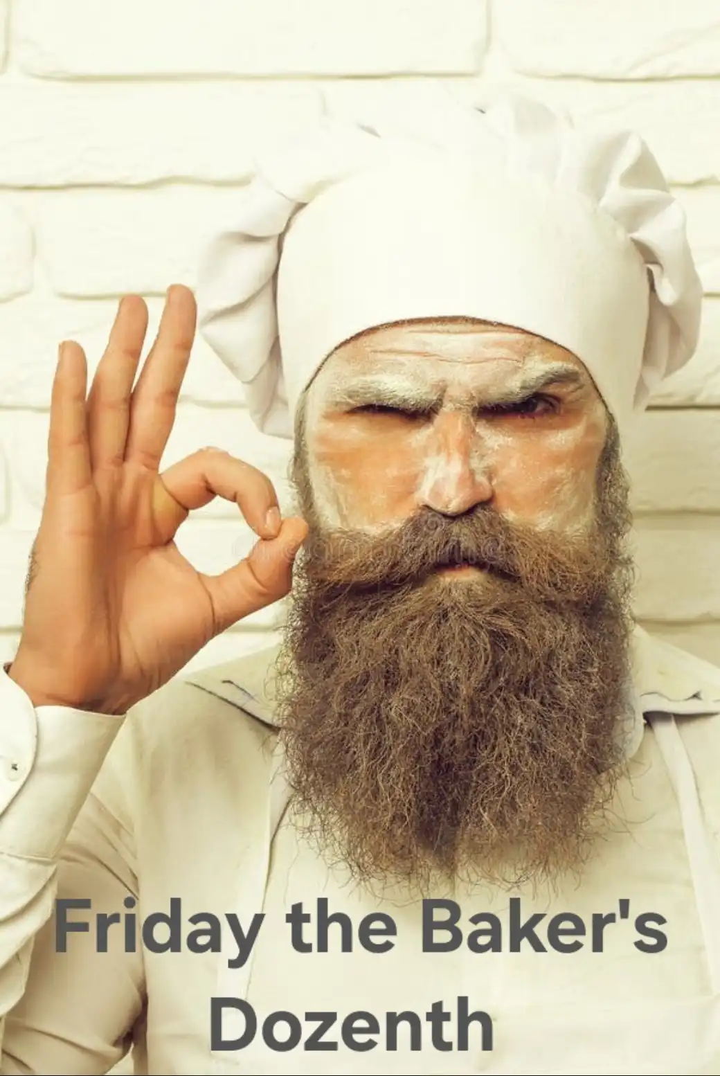 A man with a long beard and flour on his face, wearing a chef's hat and apron, makes an 'okay' hand gesture while winking…