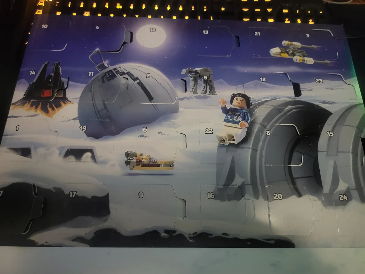A Lego Star Wars Advent Calendar featuring a snowy Hoth scene with Princess Leia in a blue sweater sitting atop a large…