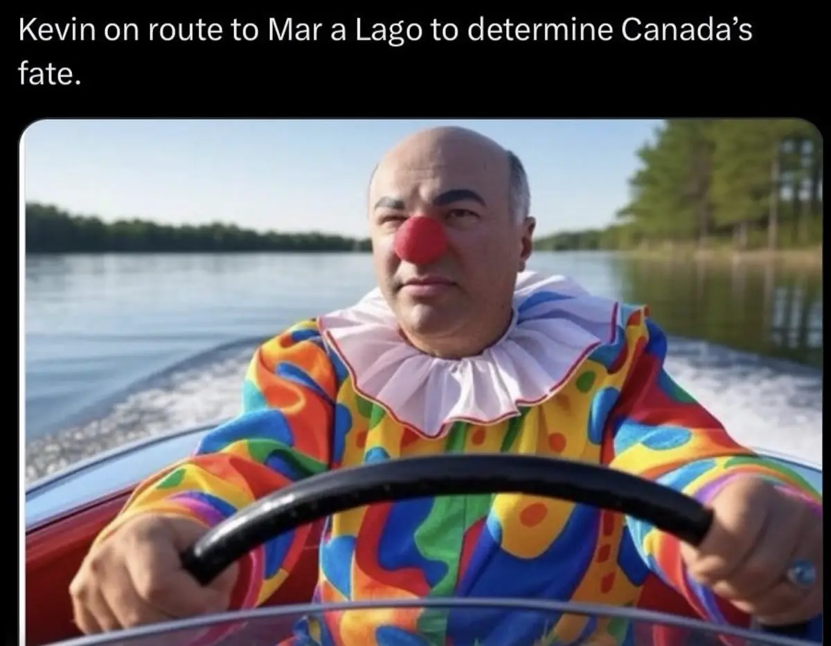 A man dressed as a clown in a colorful, patterned costume with a red nose and white ruffled collar is driving a boat…