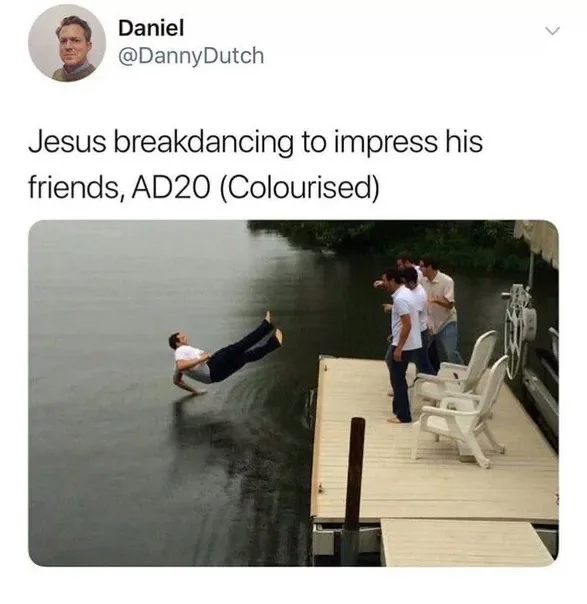 A man in a white shirt and dark pants is mid-air, performing a breakdancing move over water near a wooden dock. Several…