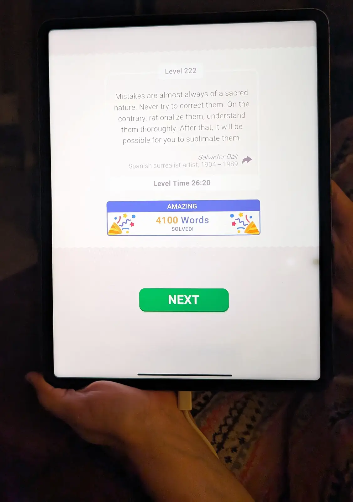 A tablet screen shows a language learning app's Level 222 completion screen, displaying a quote attributed to Salvador Dali…