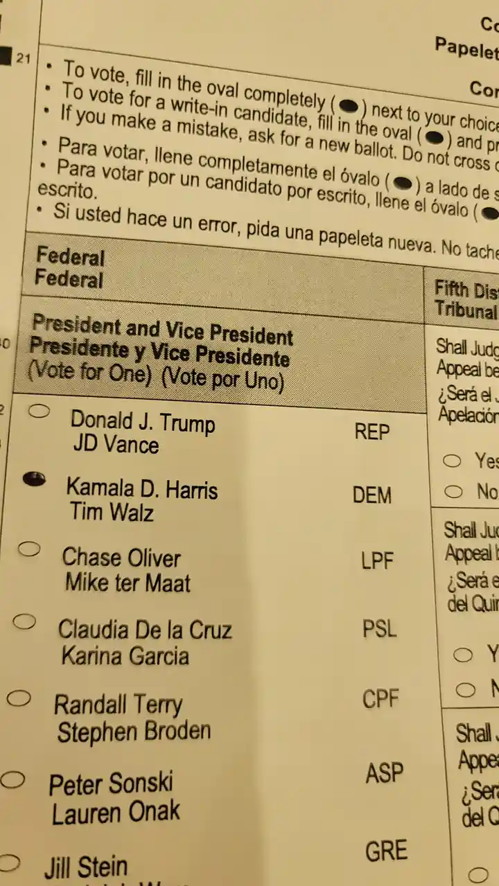 A close-up of a bilingual U.S. presidential ballot showing candidate options, with Kamala D. Harris and Tim Walz's oval…