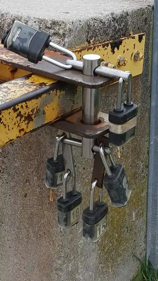 a close-up photo shows a heavy-duty industrial hitch mechanism bolted to a concrete wall, secured with multiple heavy-duty…
