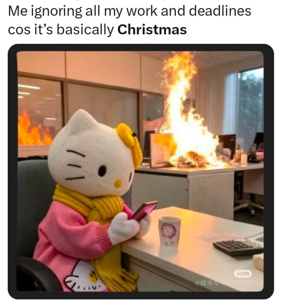 A person in a Hello Kitty mascot costume sits calmly at an office desk, wearing a pink sweater and yellow scarf, scrolling…
