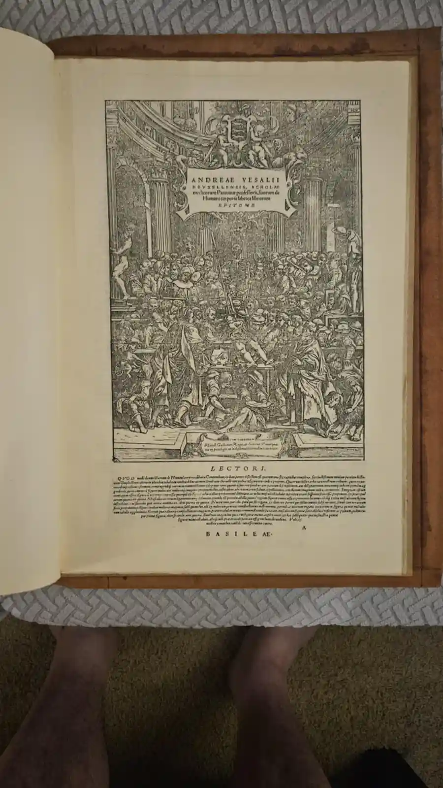 An open book displays a historical woodcut illustration from Andreas Vesalius's 'De Humani Corporis Fabrica,' showing a…