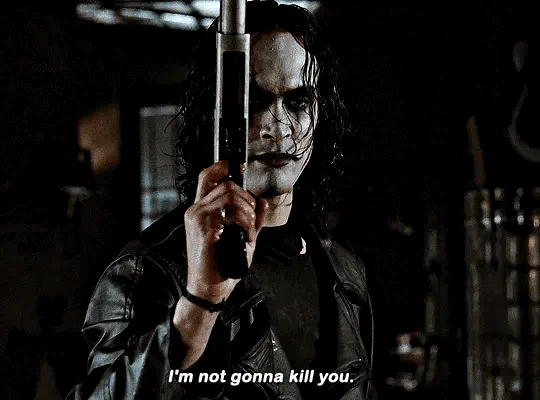 The image shows a still of the character The Joker from the movie 'The Dark Knight', holding a gun pointed forward. He is…