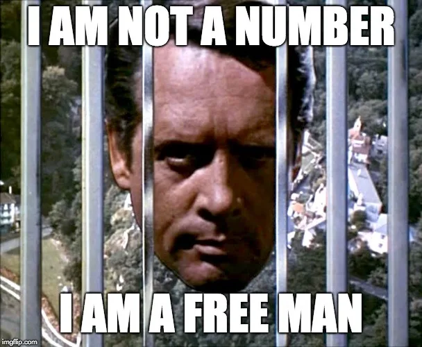 A man with a serious, defiant expression is shown behind vertical metal bars, looking directly at the viewer. The image has…