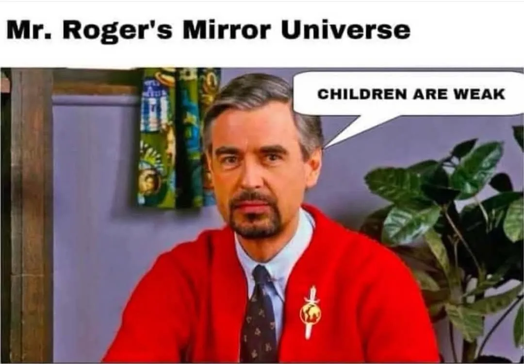 The image shows a man resembling Mr. Rogers, wearing his iconic red cardigan over a collared shirt and tie, with a serious…