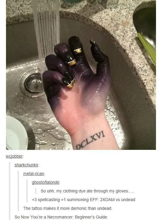 A hand with long black fingernails and purple dye staining the skin is held under a running faucet in a kitchen sink. A…
