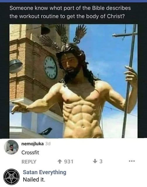 A large outdoor statue of Jesus Christ with a muscular, defined torso and feathered halo, standing before a brick building…