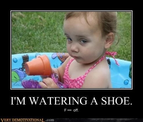 A young child with light brown hair and blue eyes sits in a blue inflatable pool, holding an orange plastic cup upside down…