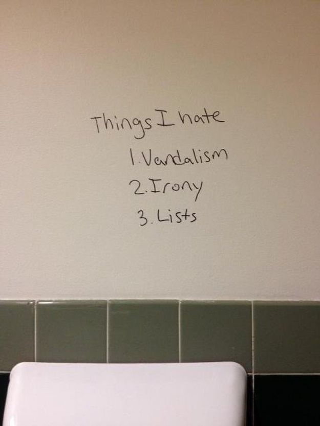 Handwritten text on a beige wall above a white toilet tank and green tiled border reads 'Things I hate' followed by a…