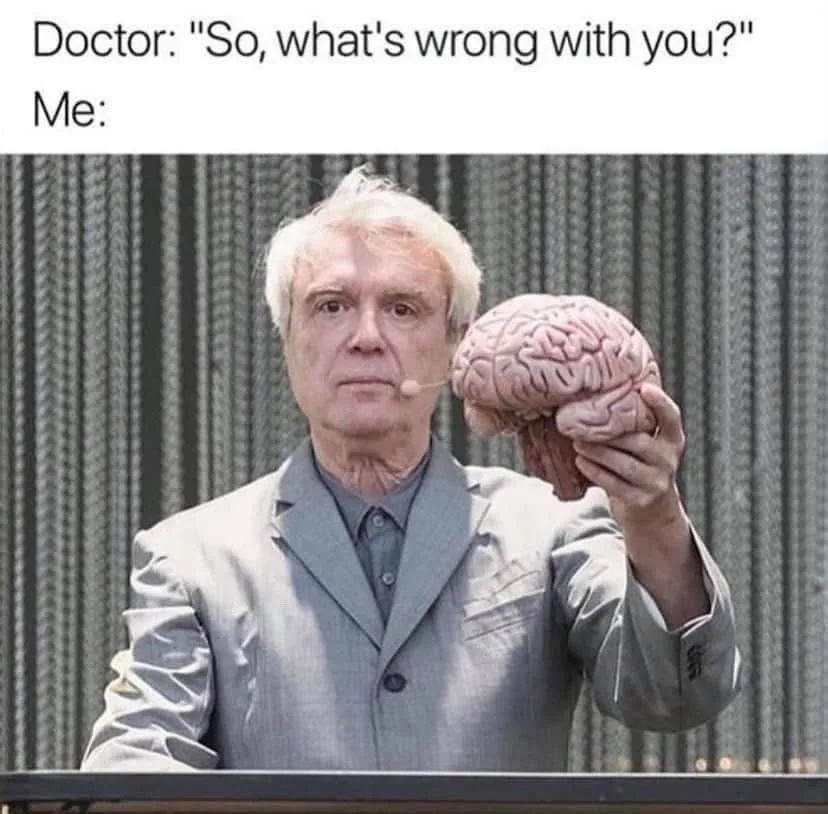 A man in a gray suit holding a human brain model while standing at a podium, with text above him reading 'Doctor: "So…