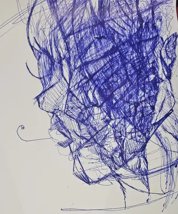 A hand-drawn sketch on white paper shows a crudely drawn face with wild, scribbled blue ink lines covering most of it…