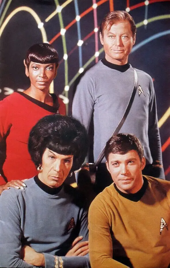 A promotional photo of the original Star Trek cast features four crew members in their iconic uniforms against a colorful…
