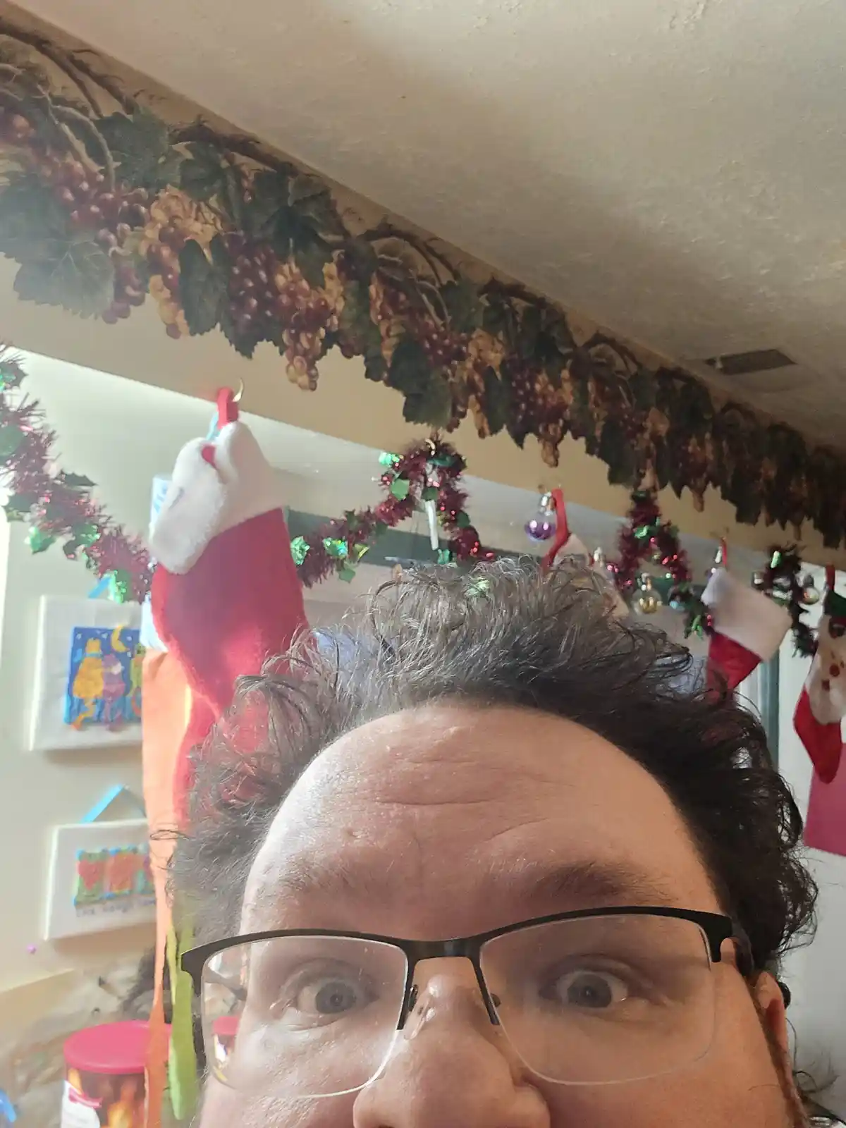 A person with glasses and wide, startled eyes looks directly at the camera from a low angle, with multiple red and white…