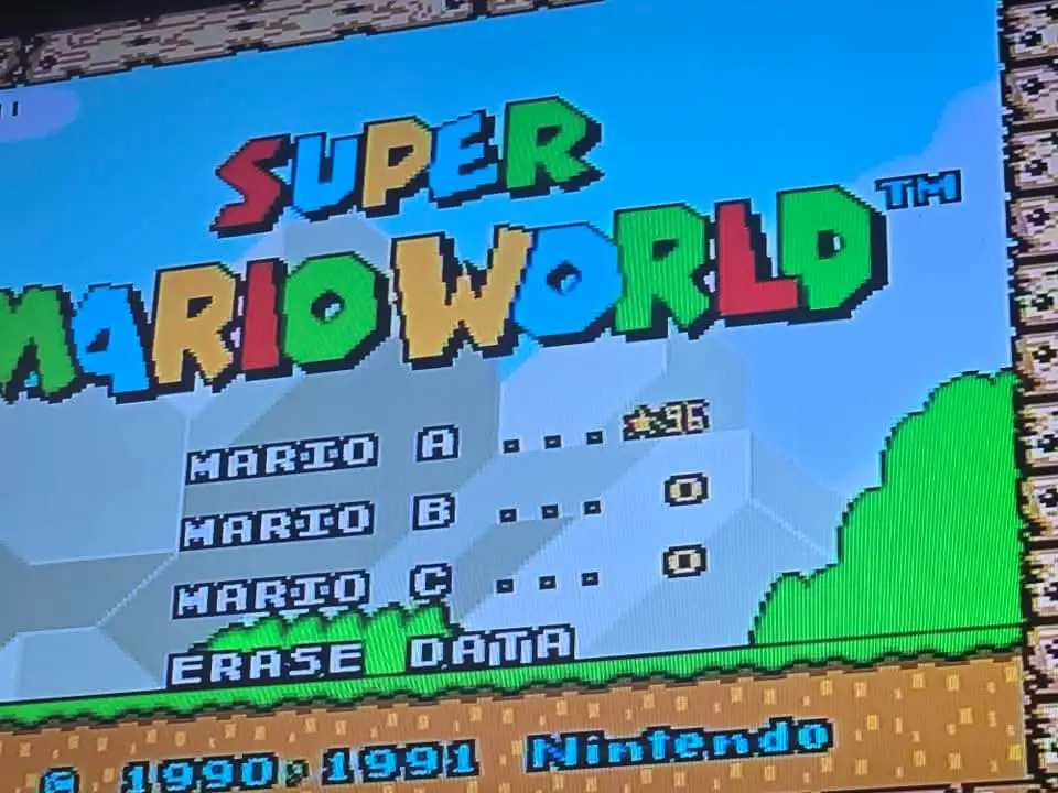 A screenshot of the Super Mario World game's save data screen, showing three player slots labeled 'MARIO A', 'MARIO B', and…