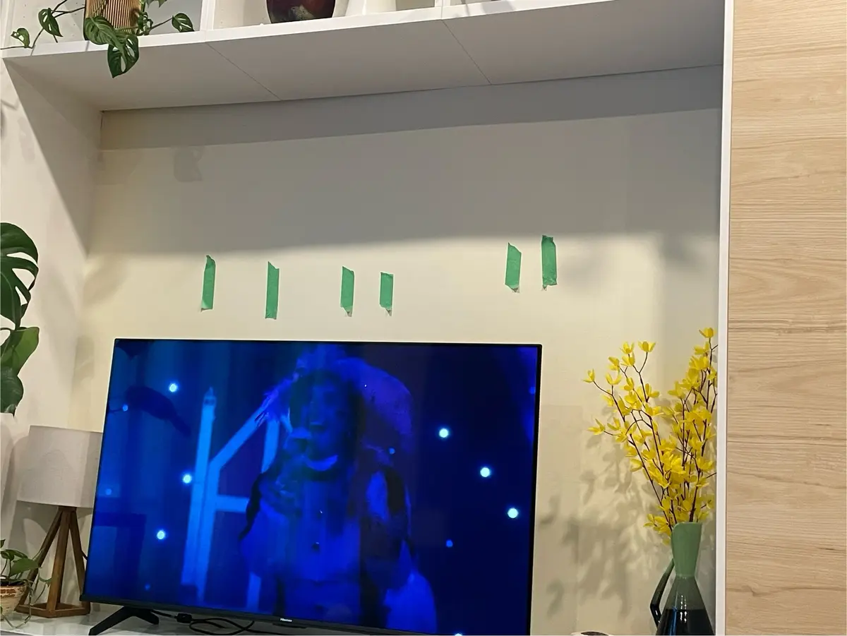 A television screen displays a blurry, blue-tinted scene of a person in what appears to be a horror or suspense setting…