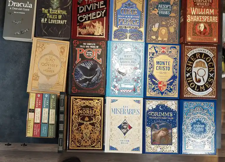 A collection of classic literature books with ornate covers, including Dracula, War and Peace, Alice's Adventures in…