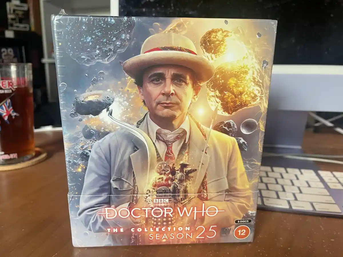 A sealed Doctor Who Season 25 DVD box set featuring the 12th Doctor, portrayed by Peter Capaldi, wearing a hat and suit…