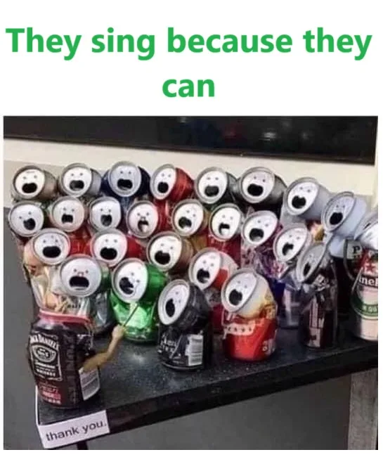A collection of beer and soda cans arranged on a shelf, each with a white circular sticker drawn on its top to resemble a…