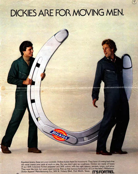 Two men in Dickies work overalls are holding a giant, curved, silver horseshoe-shaped object with the Dickies logo on it…