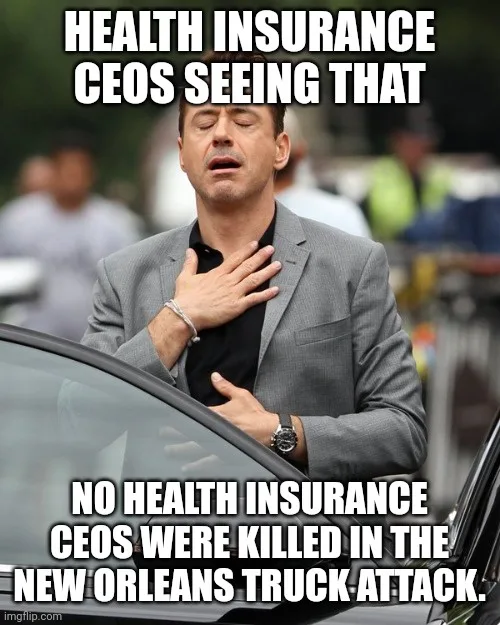 A man in a gray suit with his eyes closed and hand on his chest, appearing shocked or dismayed, stands beside a car. The…