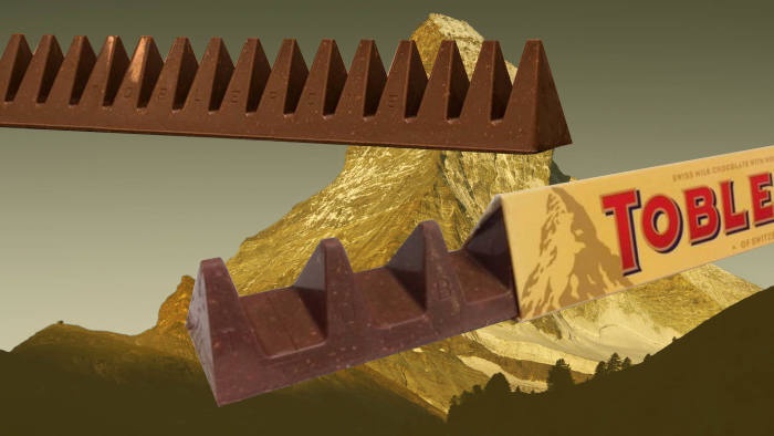 Two Toblerone chocolate bars are shown in front of a mountain range, with the brand name 'TOBLEN' visible on the wrapper and…