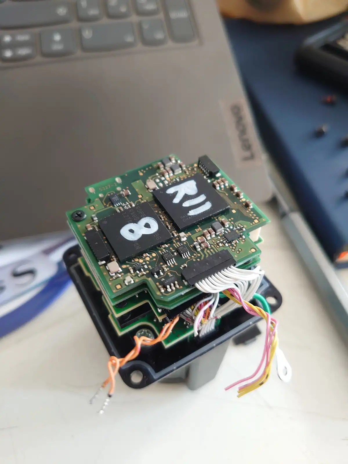 A close-up photo shows a green circuit board with two large black chips; one chip has the number '8' painted on it, the…