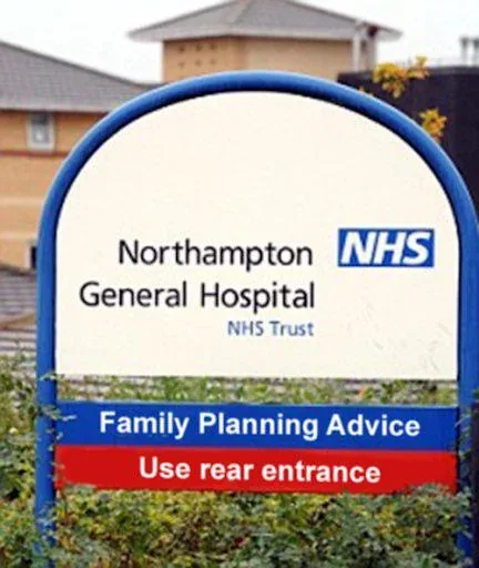 A hospital sign for Northampton General Hospital NHS Trust features a blue banner reading 'Family Planning Advice' and a red…