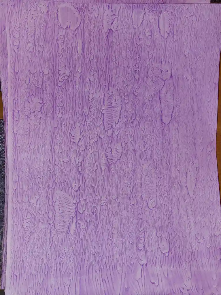 A close-up of purple textured paper with a wood grain pattern, featuring visible knots and grain lines. The overlaid text…
