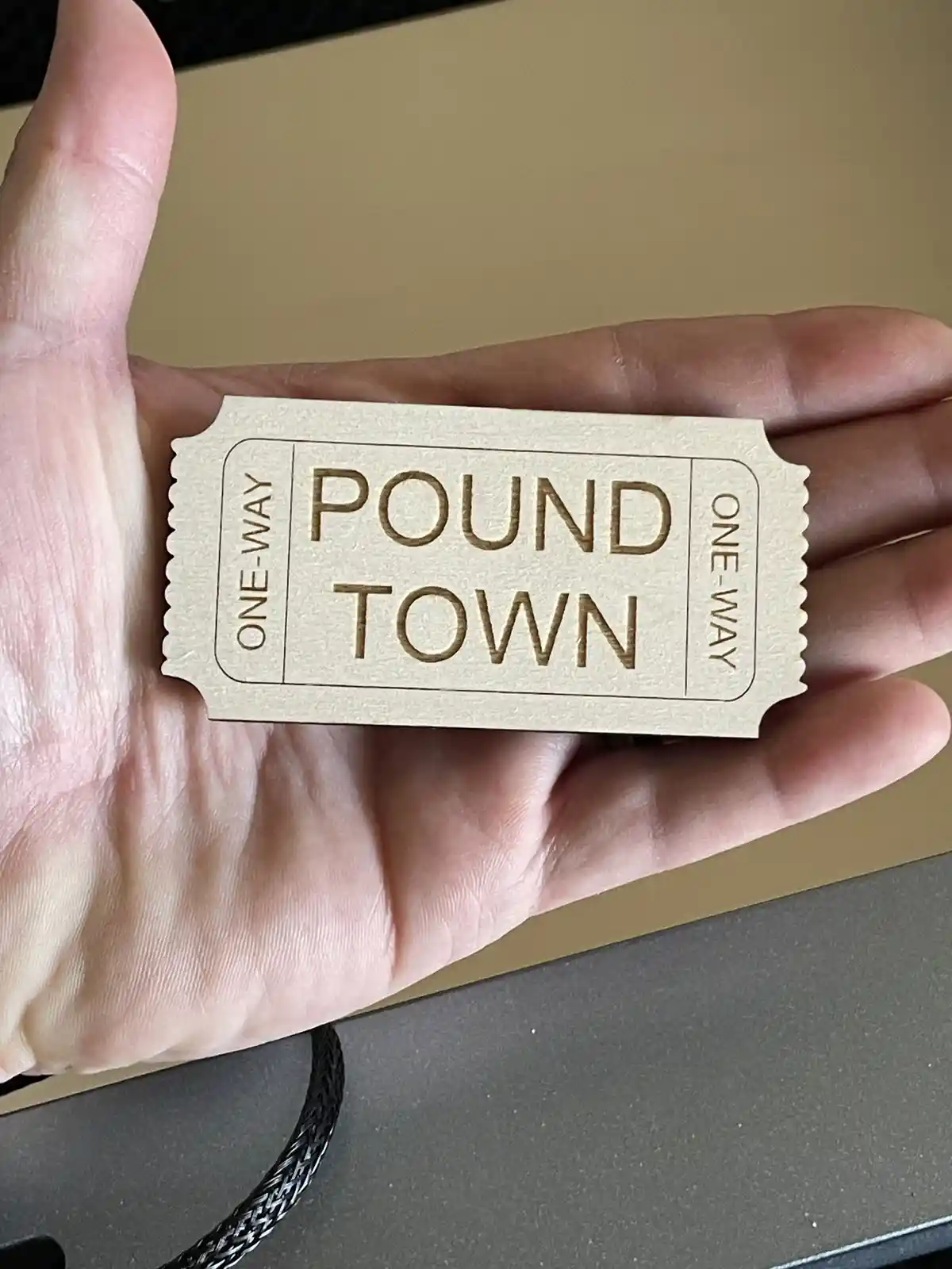 A hand holds a light-colored, ticket-shaped object with scalloped edges, resembling a boarding pass. The text 'ONE-WAY' is…