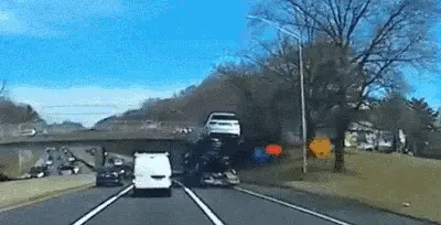 six sequential dashcam frames show a white van driving under a bridge while a large truck crashes into it, sending debris…