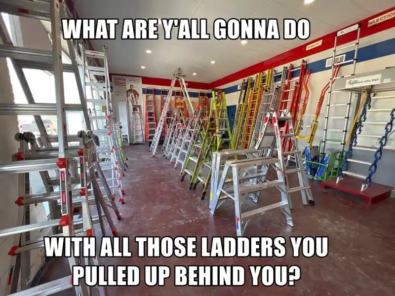 A photo of a retail store aisle filled with numerous ladders of various sizes and colors, arranged in rows. Overlaid text in…