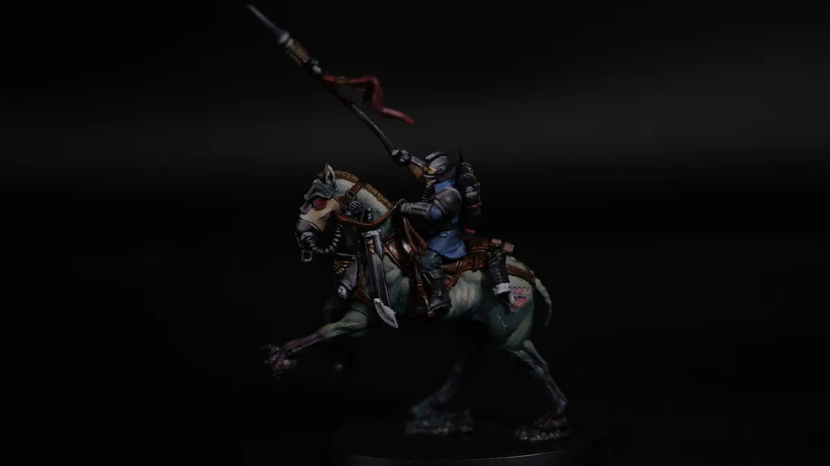 A painted miniature of a heavily armored, steampunk-style rider on a mechanical horse, both adorned with gear and weapons…